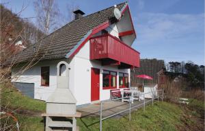 a small white and red house with a deck at Ferienhaus 44 In Kirchheim in Kemmerode