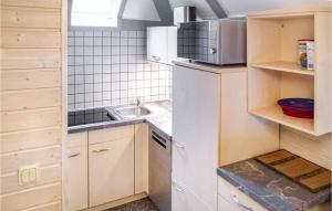 una pequeña cocina con fregadero y nevera. en Ferienhaus 44 In Kirchheim, en Kemmerode