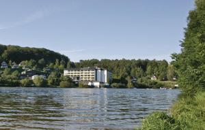ein großer See mit einem Gebäude im Hintergrund in der Unterkunft Ferienhaus 44 In Kirchheim in Kemmerode