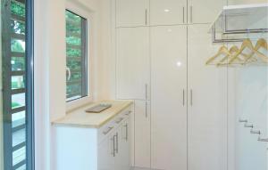 a white kitchen with white cabinets and a window at Haus 8 in Wendorf