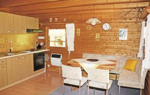 uma cozinha com mesa e cadeiras num quarto em Am Thringer Meer em Drognitz
