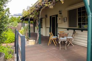 un patio con mesa y sillas. en South Freo Bungalow - Winter Centre Of Cafes, en South Fremantle