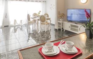 a living room with a table and a tv at Cozy Apartment In Torrevieja in Torrevieja