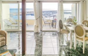 トレビエハにあるCozy Apartment In Torrevieja With House Sea Viewのリビングルーム(テーブル、椅子付)、バルコニーが備わります。