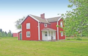 a red house with a green field in front of it at Gorgeous Home In Bodafors With Kitchen in Bodafors