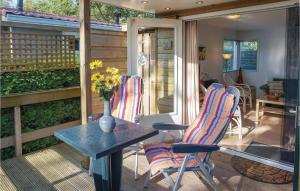 a patio with two chairs and a table and a vase with flowers at 2 Bedroom Amazing Home In Tzummarum in Tzummarum