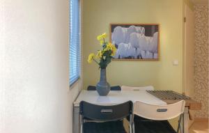 einen Esstisch mit einer Vase mit gelben Blumen darauf in der Unterkunft 2 Bedroom Amazing Home In Tzummarum in Tzummarum