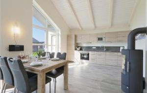 a kitchen and dining room with a wooden table and chairs at Lovely Home In Dagebll With Kitchen in Dagebüll