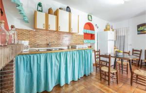 a kitchen with a sink and a table with chairs at Nice Home In Sayalonga With Wifi in Sayalonga