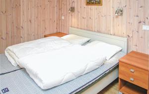 Una cama blanca en una habitación con una pared de madera. en Stunning Home In Sogndal With Sauna, en Svidalen 7 fotos más