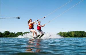 two people are on the water on water skis at Gorgeous Home In Ssel With Lake View in Süsel