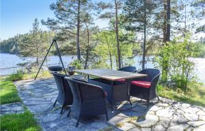a table and chairs on a patio next to a lake at Trollstua in Asak