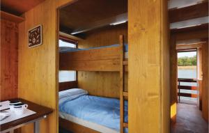 a bunk bed in a wooden cabin with a desk and a table at Lovely Ship In Radewege With Kitchenette in Radewege