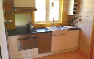 Il comprend une petite cuisine équipée d'un évier et d'une cuisinière. dans l'établissement Awesome Home In Frgelanda With 2 Bedrooms, à Muberg