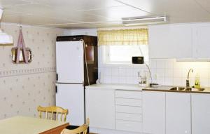 LinnerydにあるBeautiful Home In Linneryd With Kitchenのキッチン(白い冷蔵庫、テーブル付)