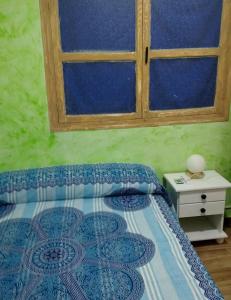 a bedroom with a bed with a window at La Casita de Martina in Sotillo de la Adrada