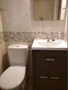 a bathroom with a white toilet and a sink at La Casita de Martina in Sotillo de la Adrada +17 photos