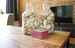 two glass bottles filled with shells on a table at Wijde Waddenzee in Den Oever