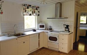 a kitchen with a sink and a stove top oven at 2 Bedroom Stunning Home In Örkelljunga in Fasalt