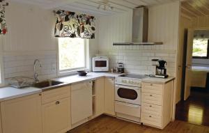 a kitchen with a sink and a stove top oven at 2 Bedroom Stunning Home In rkelljunga in Fasalt