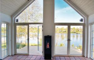 Cette chambre vide dispose de grandes fenêtres et offre une vue sur le lac. dans l'établissement Cozy Home In sljunga With Kitchen, à Åsljunga