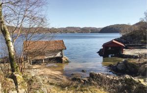 リュングダールにあるBeautiful Home In Lyngdal With Kitchenの湖畔の二棟の建物