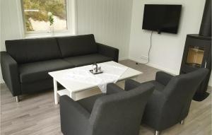 ein Wohnzimmer mit einem Sofa, einem Tisch und Stühlen in der Unterkunft Beautiful Home In Lyngdal With Kitchen in Lyngdal