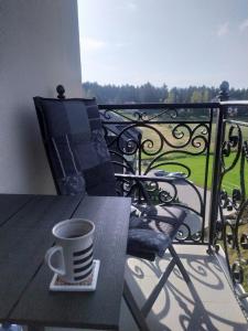 eine Tasse Kaffee auf einem Tisch auf einem Balkon in der Unterkunft Imperia M Zlatibor in Zlatibor