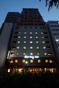 a tall building with a sign on the side of it at Dormy Inn Hiroshima in Hiroshima
