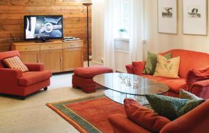 - un salon avec des chaises rouges et une table en verre dans l'établissement Cozy Home In Svngsta With Sauna, à Svängsta