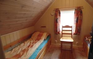 a small bedroom with a bed and a chair at Havtunet in Trolldalen
