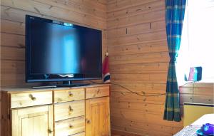 a flat screen tv sitting on top of a wooden cabinet at Nice Apartment In Vossestrand With 2 Bedrooms And Wifi in Øyjordi