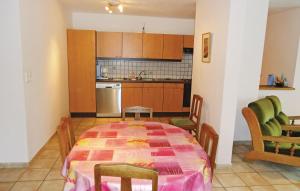 una cocina con mesa y sillas y una cocina con mesa y sillón. en Appartement B - On Lecurie, en Haut-Fays