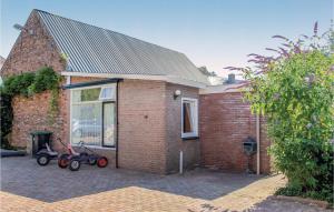 una casa de ladrillo con dos scooters estacionados fuera de ella en De Betuwe Hoeve, en Ommeren