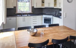 a kitchen with a wooden table with chairs around it at Awesome Home In Slen With 4 Bedrooms, Sauna And Wifi in Stöten