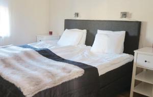 a bed with a blanket and two pillows on it at Awesome Home In Slen With 4 Bedrooms, Sauna And Wifi in Stöten