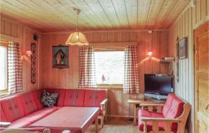 a living room with a red couch and a tv at Bassebu-updalstl in Tyinkrysset