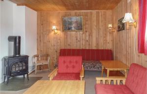 a living room with a red couch and a wood stove at Bassebuupdalstøl in Tyinkrysset