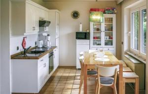 HausenにあるNice Home In Oberaula Ot Hausen With 4 Bedrooms And Wifiの白いキャビネットと木製テーブル付きのキッチン