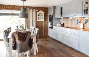 una cocina con armarios blancos y una mesa con sillas. en Gorgeous Home In Sjusjen With Kitchen en Sjusjøen