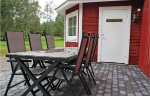 a table and chairs on a patio with a house at 2 Bedroom Lovely Apartment In Habo in Mullsjö