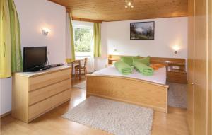 ein Schlafzimmer mit einem Bett mit grünen Kissen und einem TV in der Unterkunft Amazing Apartment In Tobadill With 4 Bedrooms And Wifi in Tobadill