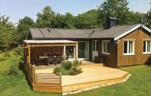 een blokhut met een terras en een tafel bij Cozy Home In Steninge With Wifi in Steninge