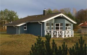 una pequeña casa azul en un campo de hierba en Meeresrauschen 3 - Dorf 6, en Priwall