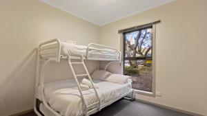 Etagenbett in einem Zimmer mit Fenster in der Unterkunft Karoondah 10 in Mount Hotham