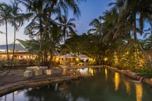 een zwembad met palmbomen en een restaurant bij Seagulls in Townsville