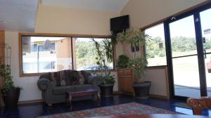 een woonkamer met een bank en een aantal planten bij Holiday Lodge & Suites in McAlester