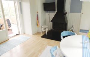 uma sala de estar com uma mesa e uma lareira em 1 Bedroom Lovely Home In Oskarstrm em Årnilt