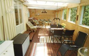 a screened in porch with a table and chairs at 1 Bedroom Lovely Home In Oskarstrm in Årnilt