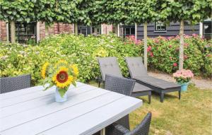 een vaas met zonnebloemen op een tafel met stoelen bij Het Vissershuisje in Wijdenes